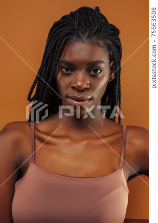 pretty young african american woman with braids posing cheerful gesturing on brown background, lifestyle people concept pretty young african american woman with braids posing cheerful gesturing on brown background, lifestyle people concept 75663508