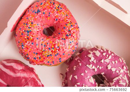 Multi-colored donuts in a white box close-up. Multi-colored donuts in a white box close-up. 75663692