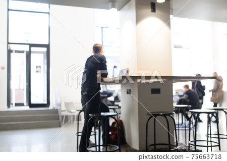 Blurred photo of a cafe with people. Coffee shop with a white interior. Blurred photo of a cafe with people. Coffee shop with a white interior. 75663718