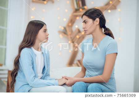 Sad daughter and understanding mom sitting at home Sad daughter and understanding mom sitting at home 75665309