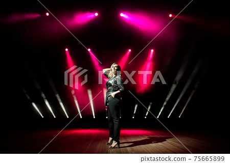 Young woman singer with colorful lights on concert Young woman singer with colorful lights on concert 75665899