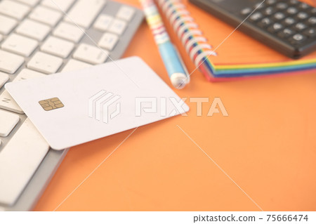 credit cards, keyboard and notepad on orange background credit cards, keyboard and notepad on orange background 75666474