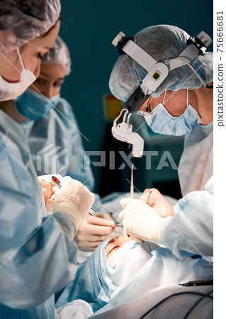 Rhinoplasty men, the surgeons gloved hands hold the instruments during nose surgery. Doctor in gloves holds a medical instrument during rhinoplasty 75666681