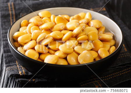 Diet appetizer pickled lupine beans close-up in a bowl. horizontal 75668071