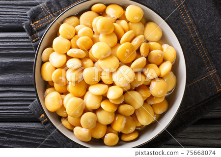 Salted yellow lupine beans close-up in a bowl. horizontal top view 75668074