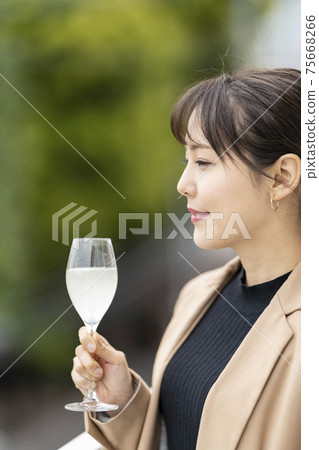 Women drinking sake in a wine glass lifestyle Women drinking sake in a wine glass lifestyle 75668266