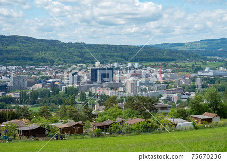 View over the green meadows of Limmattal. Switzerland, towards the urban valley 75670236