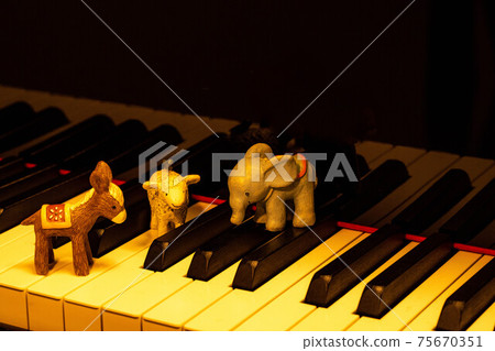 在一架三角鋼琴的鍵盤上擺放著驢，大象和卵巢的小雕像 75670351