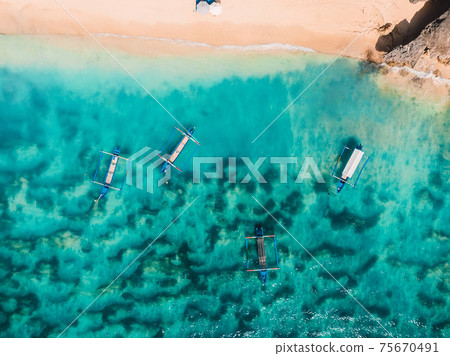 Sandy beach with turquoise ocean water and boats, aerial view Sandy beach with turquoise ocean water and boats, aerial view 75670491