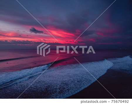 Aerial view of ocean with waves and colorful sunset or sunrise. Aerial view of ocean with waves and colorful sunset or sunrise. 75670492
