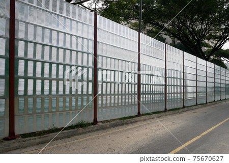 SELANGOR, MALAYSIA - JULY 2, 2020: Noise barriers are installed along the vehicle lane bordering the residence to prevent noise pollution to the locals. 75670627