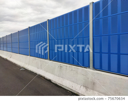 SELANGOR, MALAYSIA - JULY 2, 2020: Noise barriers are installed along the vehicle lane bordering the residence to prevent noise pollution to the locals. 75670634