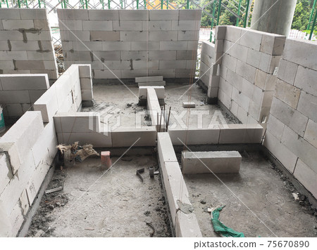 SEREMBAN, MALAYSIA -MARCH 15, 2020: Blockwork by construction workers at the construction site. Workers laying the AAC brick and stacked it together using mortar to form the wall.  75670890