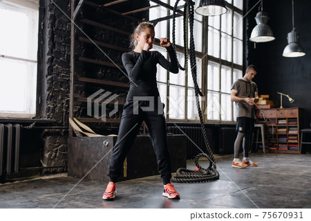 cool female fighter in boxing gloves trains in the gym. Mixed martial arts 75670931