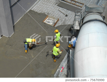 JASIN, MALAYSIA -SEPTEMBER 05, 2016: Construction workers leveling wet concrete has been poured. They also use a vibrator machine in this work. JASIN, MALAYSIA -SEPTEMBER 05, 2016: Construction workers leveling wet concrete has been poured. They also use a vibrator machine in this work. 75670990