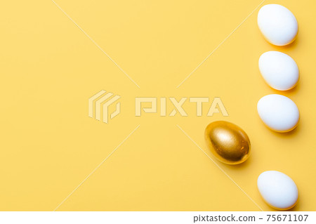 Easter decoration. Golden, white colour egg on pastel yellow background in Happy Easter decoration. Foil minimalist egg design with copy space. Easter decoration. Golden, white colour egg on pastel yellow background in Happy Easter decoration. Foil minimalist egg design with copy space. 75671107