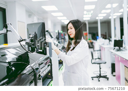 young female scientist working with automation blood analyzer report in medical laboratory young female scientist working with automation blood analyzer report in medical laboratory 75671210