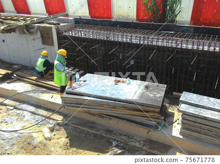 JOHOR, MALAYSIA -JANUARY 18, 2017: Construction workers fabricating steel reinforcement bar at the construction site in Johor, Malaysia. The reinforcement bar was ties together using tiny wire.     75671778