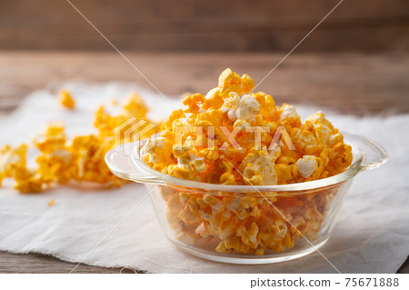 Caramel popcorn in glass bowl on wooden table background 75671888