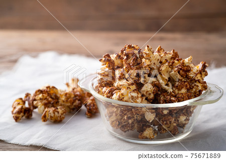 Chocolate popcorn in glass bowl on wooden table background 75671889