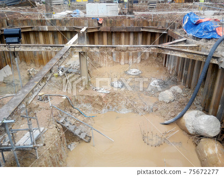 PUTRAJAYA, MALAYSIA -OCTOBER 13, 2017: Sheet pile cofferdam retaining wall at the construction site. It is installed to allow soil excavation and foundation work start. PUTRAJAYA, MALAYSIA -OCTOBER 13, 2017: Sheet pile cofferdam retaining wall at the construction site. It is installed to allow soil excavation and foundation work start. 75672277