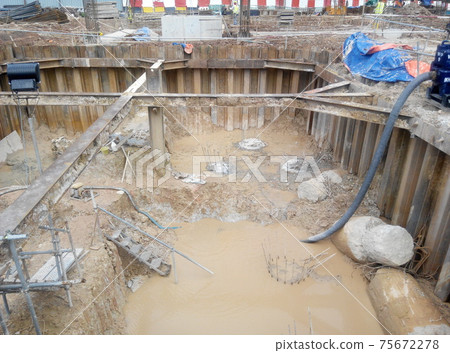 PUTRAJAYA, MALAYSIA -OCTOBER 13, 2017: Sheet pile cofferdam retaining wall at the construction site. It is installed to allow soil excavation and foundation work start. PUTRAJAYA, MALAYSIA -OCTOBER 13, 2017: Sheet pile cofferdam retaining wall at the construction site. It is installed to allow soil excavation and foundation work start. 75672278
