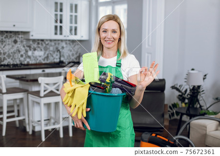 Woman showing sign ok and holding bucket with cleaning tools 75672361