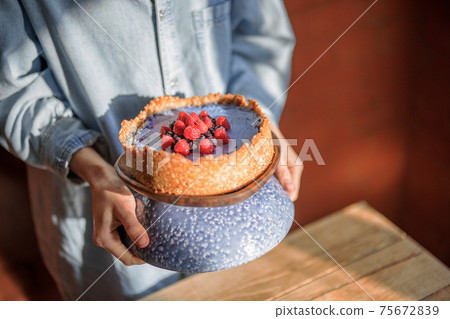 Woman putting cheesecake on a dinner table 75672839