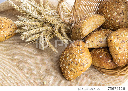 Freshly baked bread. Fresh loaf of rustic traditional bread with wheat grain ear or spike plant on linen texture background. Rye bakery with crusty loaves and crumbs. Healthy Food concept. 75674126