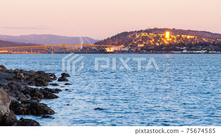 View of Iron Workers Memorial Bridge and Vancouver Shore skyline cityscape in dusk. British Columbia, Canada. 75674585