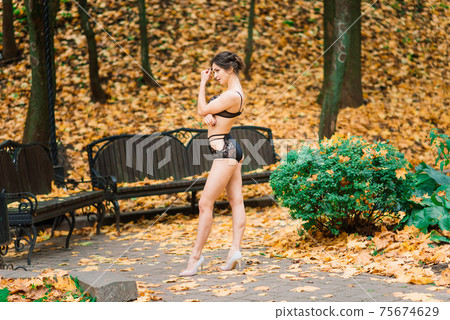 Beautiful young woman in lingerie in autumn forest Beautiful young woman in lingerie in autumn forest 75674629