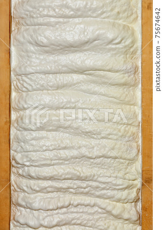 Texture and background of a wall made of construction foam between two wooden beams. 75674642