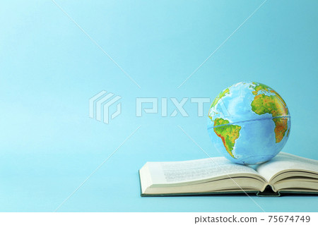 Earth globe on an open book on a blue banner background. Knowledge, learning, study concept. Backagrund education Earth globe on an open book on a blue banner background. Knowledge, learning, study concept. Backagrund education 75674749
