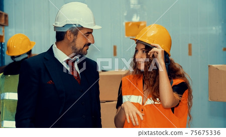 Warehouse senior manager talking to worker in the storehouse Warehouse senior manager talking to worker in the storehouse 75675336