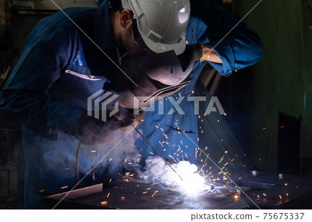 Skillful metal worker working with arc welding machine in factory Skillful metal worker working with arc welding machine in factory 75675337