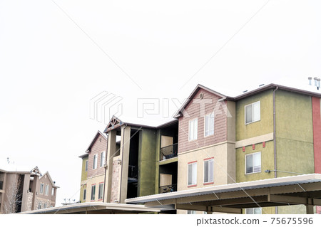 Apartment building with foucs on the upper storey exetrior against white sky Apartment building with foucs on the upper storey exetrior against white sky 75675596
