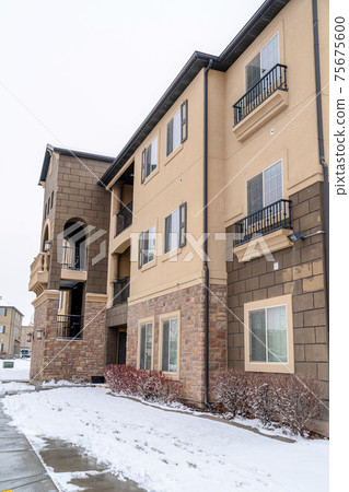 Multi storey apartment in a snowy neighborhood against white sky in winter Multi storey apartment in a snowy neighborhood against white sky in winter 75675600