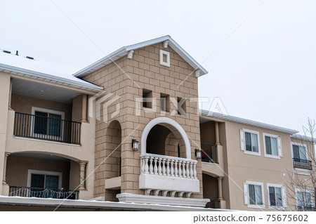 Residential apartment building facade with gabled front design and balconies Residential apartment building facade with gabled front design and balconies 75675602