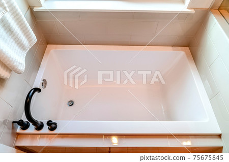 Top view of a built in rectangular bathtub inside the clean bathroom of a home 75675845