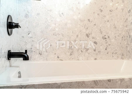 Built in bathtub and black faucet with single lever handle inside bathroom Built in bathtub and black faucet with single lever handle inside bathroom 75675942