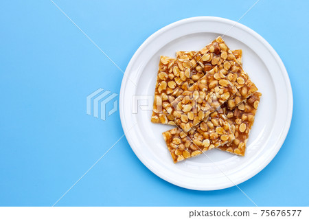 Honey bars with peanuts on blue background Honey bars with peanuts on blue background 75676577