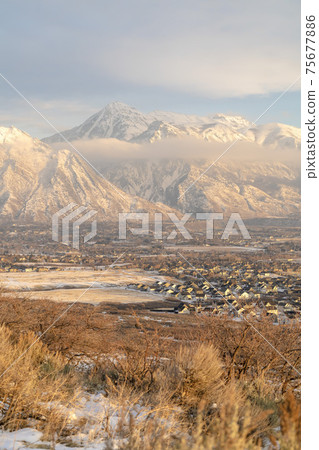 Mount Timpanogos hills and houses blanketed with snow on a cold winter day Mount Timpanogos hills and houses blanketed with snow on a cold winter day 75677886