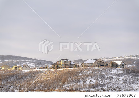 Houses on residential area nestled on hills blanketed with snow in winter Houses on residential area nestled on hills blanketed with snow in winter 75678908