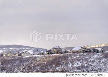 Tranquil residential area on a hill top covered with fresh snow on a winter day Tranquil residential area on a hill top covered with fresh snow on a winter day 75678912