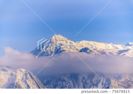 Striking snow covered Mount Timpanogos with blue sky background in winter Striking snow covered Mount Timpanogos with blue sky background in winter 75678915