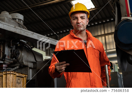Skillful factory worker working with clipboard to do job procedure checklist . Skillful factory worker working with clipboard to do job procedure checklist . 75686358