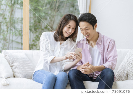 Men and women looking at smartphones together 75691076