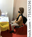 Female waiting the vaccination injection in medical mask.  75692296