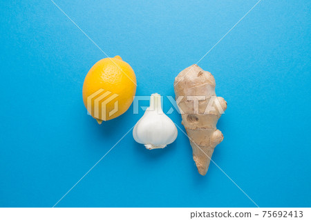 Lemon garlic ginger on a blue background. The body's natural defense against disease. 75692413