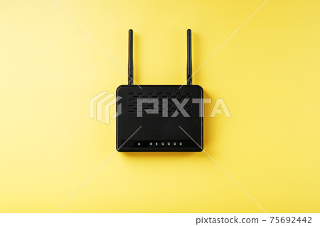 Black Wi-Fi router on a yellow background with free space. Black Wi-Fi router on a yellow background with free space. 75692442